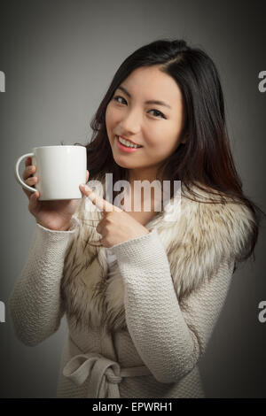 Attraente ragazza asiatica nel suo ventenne isolato su un sfondo plein girato in uno studio Foto Stock