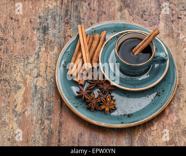 Tazza di caffè nero con cannella e anice stellato spezie. In stile vintage still life Foto Stock