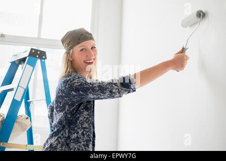 Donna pittura camera bianca Foto Stock