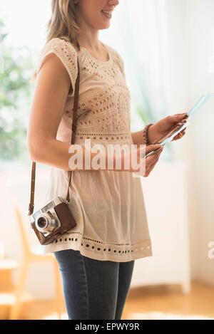 Donna che mantiene antiche della fotocamera e delle foto Foto Stock