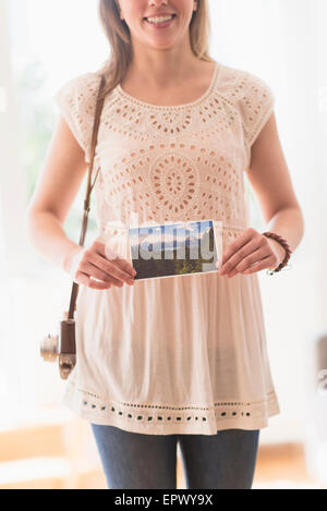 Donna che mantiene antiche della fotocamera e delle foto Foto Stock