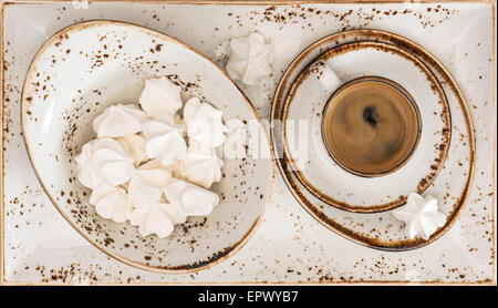 Nero caffè con biscotti di meringa. Stile retrò vasellame di porcellana. Vista superiore Foto Stock