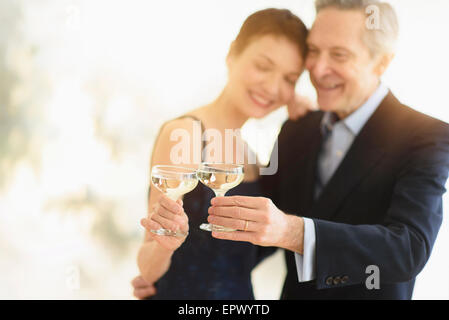 Elegante coppia senior che festeggiano il loro anniversario con toast champagne Foto Stock