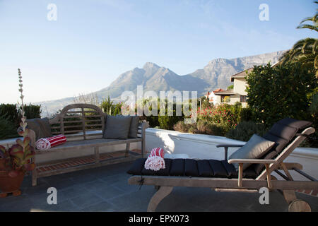 Panca in legno e sdraio sulla terrazza con vedute di Table Mountain, Sud Africa Foto Stock