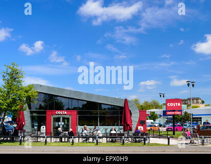 La gente seduta fuori a bere a Costa Coffee shop e drive-thru. Su Castle Marina Retail Park, a Nottingham, Inghilterra. Foto Stock