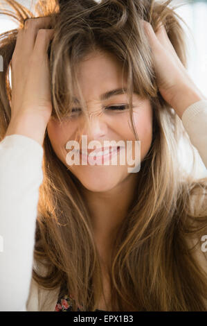 Giovane donna tirando i capelli Foto Stock