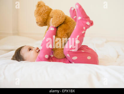 La ragazza (2-3) giacente sul letto con Teddy bear Foto Stock