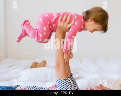 La madre gioca con la ragazza (2-3) sul letto Foto Stock