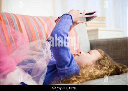 La ragazza (10-11) indossando tutu holding tavoletta digitale Foto Stock