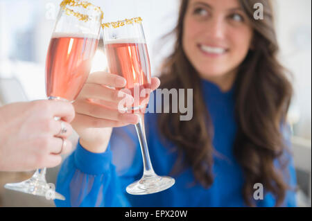 Donna fare un brindisi con un altro Foto Stock