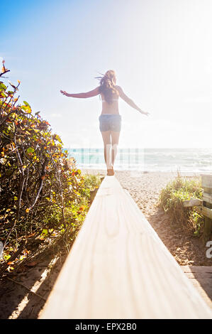 Stati Uniti d'America, Florida, Giove, giovane donna in equilibrio su boardwalk Foto Stock
