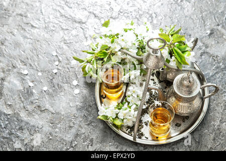 Bicchieri di tè e pot. Oriental vasellame in argento. Fiori di Primavera decorazione. Messa a fuoco selettiva Foto Stock