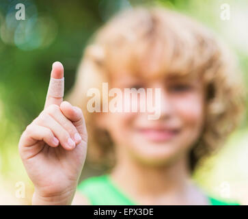 Ritratto di ragazzo (8-9) con bendaggio adesivo sul suo dito Foto Stock