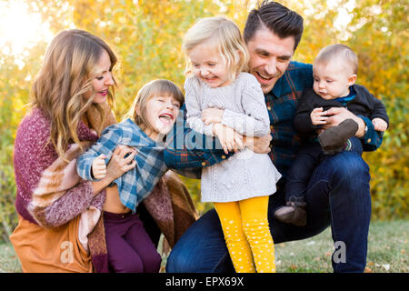 La famiglia felice con tre bambini (6-11 mesi, 2-3, 4-5) giocando in posizione di parcheggio Foto Stock