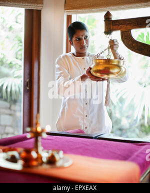 Una spa terapista prepara il Sariva Camera per Shirodhara trattamento ayurvedico ad Ananda Spa, Ananda in Himalaya. Foto Stock