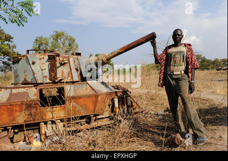 Sudan del Sud, Stato dei Laghi, Rumbek, relitto di un'auto corazzata a sei ruote FV601 Saladin, fabbricato dalla fabbrica Alvis di Coventry, Regno Unito, il carro è stato catturato dall'esercito di liberazione sudanese SLPA dalle forze armate sudanesi SAF durante la seconda guerra civile sudanese dal 1983 al 2005, uomo con T-shirt con immagine di John Garang l'ex leader dell'SPLA e eroe nazionale di oggi Foto Stock