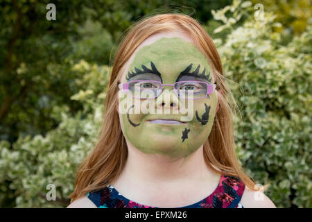 I giovani di 11 anni ragazza con sindrome di Down, con la faccia dipinta come una strega Foto Stock