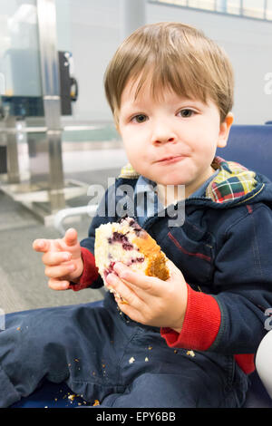 Ritratto di un ragazzo di mangiare panino dolce Foto Stock