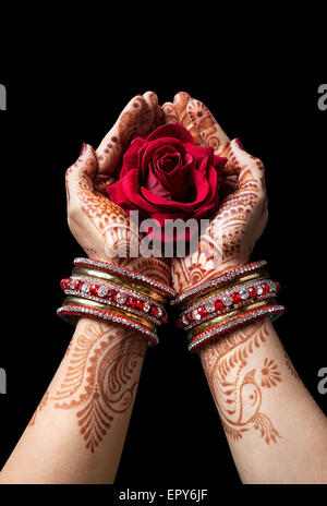 Donna mani con henna azienda red rose isolati su sfondo nero con tracciato di ritaglio Foto Stock