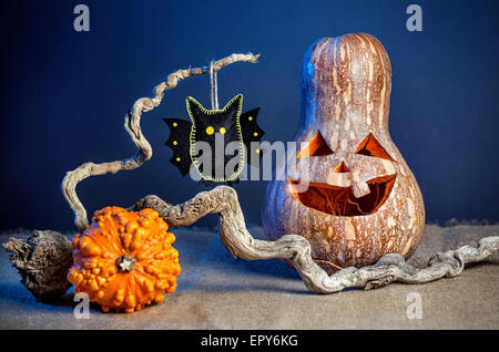 La zucca intagliata e nero bat dal feltro sul ramo a festa di Halloween Foto Stock