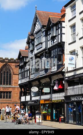 Edifici e negozi lungo Bridge Street con la chiesa di St Peters alla parte posteriore di Chester, Cheshire, Inghilterra, Regno Unito, Europa occidentale. Foto Stock