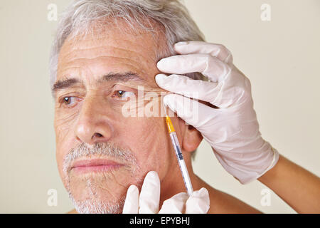 Il vecchio uomo getting rughe trattamento contro il Crow's piedi nella clinica di bellezza Foto Stock