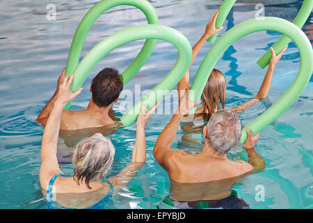 Gruppo di alti di persone facendo fitness acquatico da dietro con swim tagliatelle Foto Stock