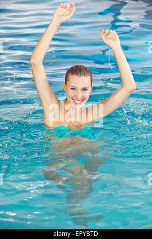 Donna felice di balneazione in piscina in estate in un hotel Foto Stock