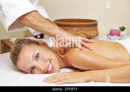 Donna sorridente getting massaggio alla schiena in salute resort spa Foto Stock