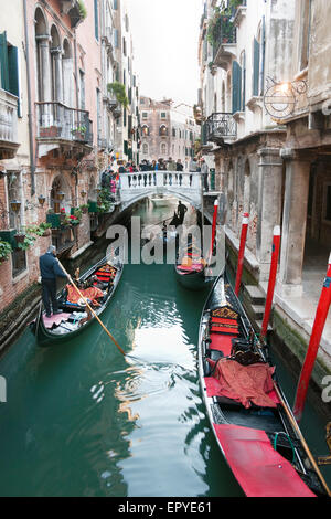 Uno stretto canale con gondole attraversando a Venezia, Italia Foto Stock