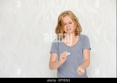 Arrabbiato giovane donna carte di ripping Foto Stock