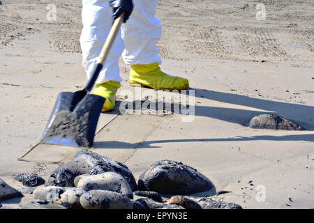 Gli equipaggi di pulizia olio sacchetto di sabbia coperte durante una spiaggia pulita fino a seguito lungo il Refugio del Parco Statale 22 maggio 2015 vicino a Santa Barbara, California. Più di 105.000 galloni di petrolio greggio fuoriuscito da una pipeline in uno dei più scenografici tratti di costa nel membro. Foto Stock