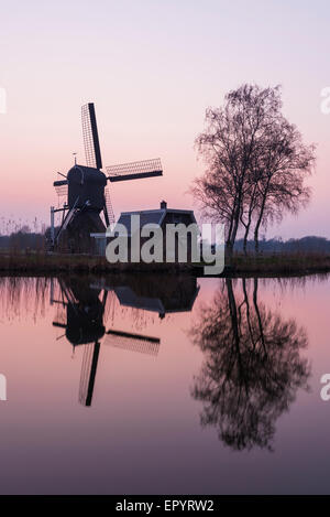 Mulino a Woerdens Verlaat dopo il tramonto vicino alla Kromme Mijdrecht e con refelection nell'acqua. Foto Stock