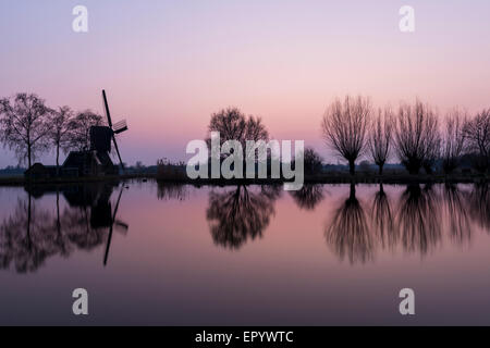 Mulino a Woerdens Verlaat dopo il tramonto vicino alla Kromme Mijdrecht e con refelection nell'acqua. Foto Stock