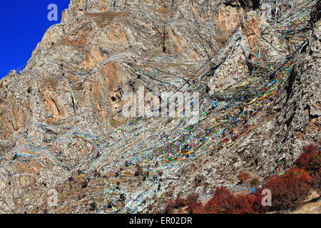 La preghiera buddista bandiere appeso sul pendio di montagna sopra il Drak Yerpa monastero-complesso di grotte di meditazione. Il Tibet Foto Stock