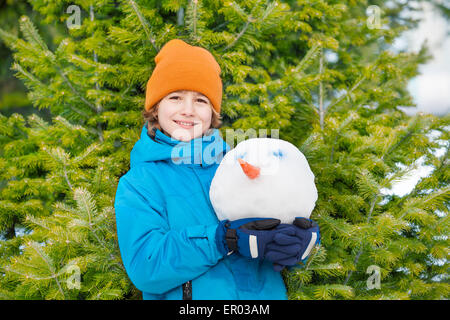 Ritratto di sorridere kid holding pupazzo di neve la testa Foto Stock