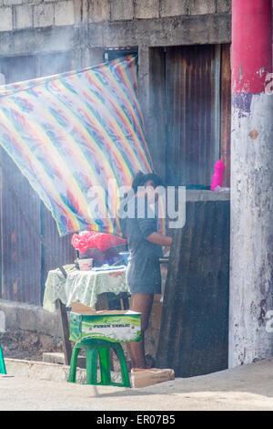 Teenage ragazza guatemalteca tortilla di cottura per la vendita su strada in Guazacapan Guatemala Foto Stock