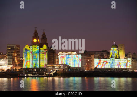 Cunard Line spedizione celebra il suo 175mo anniversario con un evento chiamato una città magnifica. Tre regine di Cunard - si tratta di tre navi - Queen Mary 2 Queen Victoria e la Queen Elizabeth vela in Liverpool insieme. La foto mostra la Cunard nave Queen Mary 2 nave contro la famosa in tutto il mondo Cunard Building, centro sul lungomare di Liverpool illuminato da fuochi d'artificio nella celebrazione. A sinistra del centro è il Royal Liver Building e alla destra del centro è il porto di Liverpool Building Foto Stock