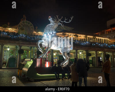 Persone per scattare foto di notte dalla incandescente renne di Covent Garden 2014 decorazioni di Natale Foto Stock