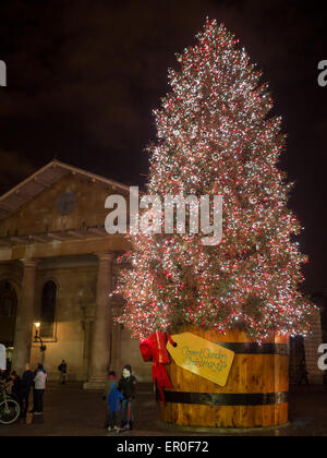 Persone per scattare foto di notte dalla incandescente albero di Natale di Covent Garden Foto Stock