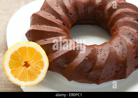 Cioccolato torta di miele e metà di succo di limone sulla piastra bianca close up Foto Stock