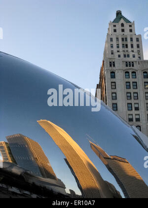 Distorto riflessi speculari di edifici vicini sono visto guardando il fagiolo, una scultura ellittica a Chicago, Illinois, Stati Uniti d'America. Foto Stock