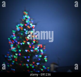 Sfocata albero di Natale con bokeh cuore forma di luci Foto Stock