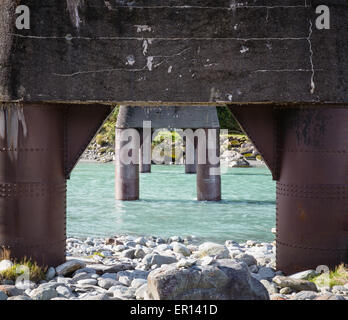 Supporti di una strada in disuso ponte sopra il lattiginoso Waiho Blue River vicino ghiacciaio Franz Josef nell Isola del Sud della Nuova Zelanda Foto Stock