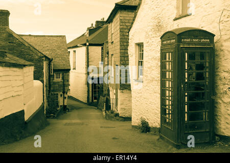 Back Lane in Port Isaac, Cornwall con vecchio stile British Phone Booth con la comunicazione moderna segni effetto antico per soddisfare Foto Stock