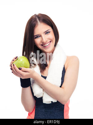 Sorridente donna fitness con asciugamano azienda mela verde isolato su uno sfondo bianco. Guardando la fotocamera Foto Stock