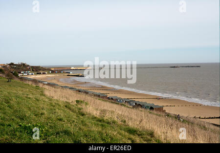 Una vista di Walton-on-the-Naze, Essex pier e spiaggia di sabbia in una giornata di sole. Cabine sulla spiaggia, linea la promenade. Foto Stock