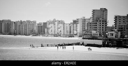 Distante alberghi e appartamenti in no mans land Varosha Famagosta linea spiaggia vuota poiché l invasione turca del 1974. Foto Stock