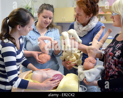 Medical educatore Bianca Huenlich (2-R) spiega il processo di nascita per la consegna agli studenti di infermiere Kelly (R-L), Kristin e Almut durante la loro formazione ostetrica presso il Policlinico di Lipsia, in Germania, il 22 aprile 2015. Il unamolla ostetriche sono tre dei 20 studenti nel loro secondo anno di loro 3 anno di apprendistato presso il Medizinische Berufsfachschule (lit. Medical Scuola Professionale) dell'università. Foto: Waltraud Grubitzsch/dpa Foto Stock