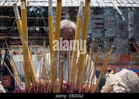 Cheung Chau isola. 25 Maggio, 2015. Un adoratore luci incenso davanti al piu Sik Parade presso Bun Festival in Cheung Chau isola il 25 maggio 2015 a Hong Kong. Uno di Hong Kong è più colorato celebrazione culturale eventi, Cheung Chau Bun Festival, sarà di scena il 25 maggio 2015 fino al 26 maggio 2015 a mezzanotte. Ogni anno migliaia e migliaia di persone scendono sulla piccola isola per i piu Sik Parade, Lucky Bun e il BUN Concorso di scrambling, l antica usanza durante il festival. La tradizione è stata tramandata per generazioni. Credito: Xaume Olleros/Alamy Live News Foto Stock